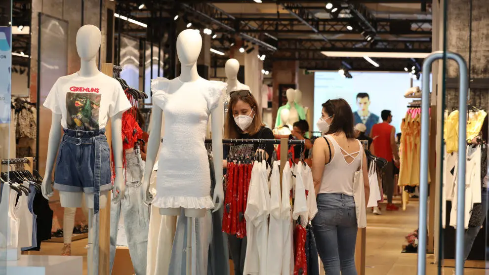 Personas con mascarilla en el interior de una tienda de ropa