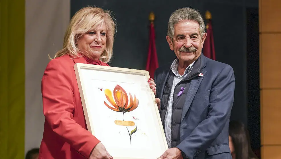 La presidenta del Colegio de Enfermeras y Enfermeros de Cantabria, Mari Luz Fernández, recoge el homenaje del PRC de manos de su secretario general, Miguel Ángel Revilla