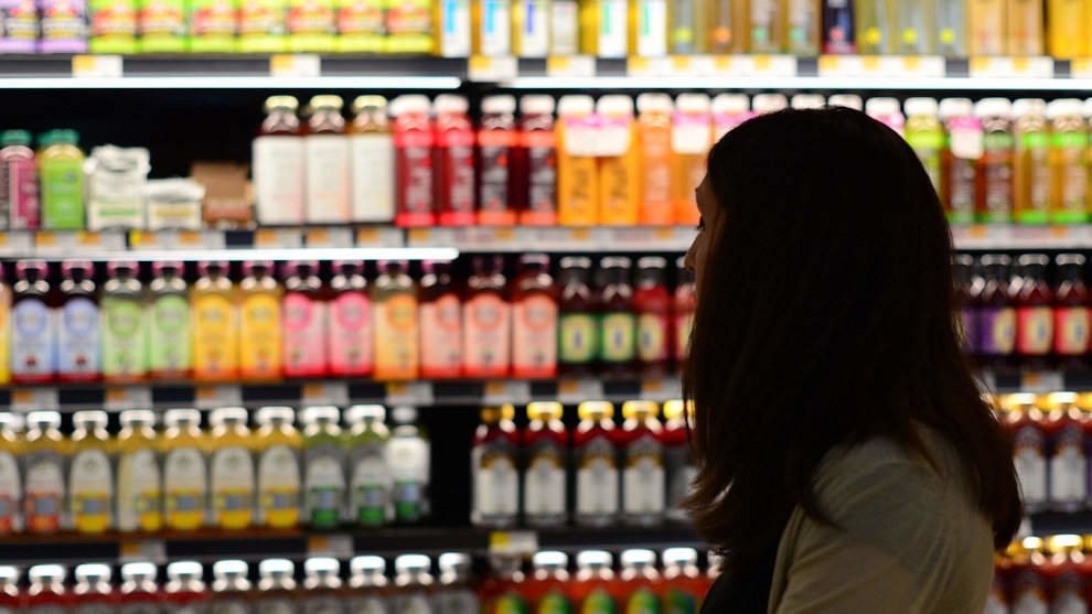 Una mujer en la sección de cosmética de un supermercado