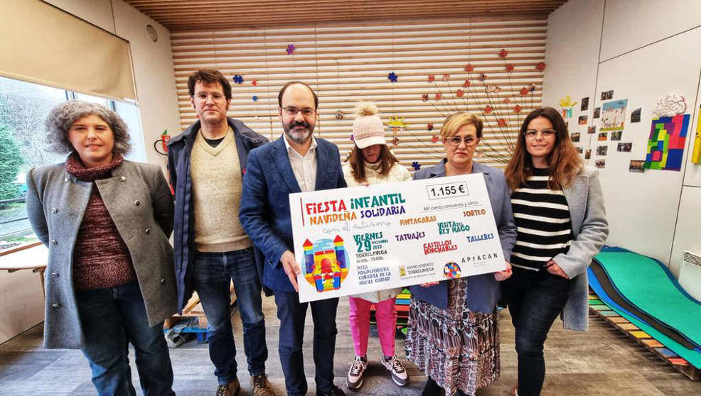 El primer teniente de Alcalde de Torrelavega, José Luis Urraca, hace entrega a APTACAN del cheque solidario