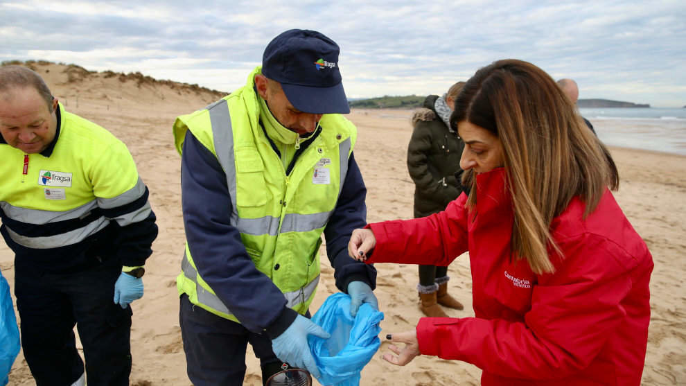  La presidenta de Cantabria, María José Sáenz de Buruaga, se une a las labores de vigilancia y retirada de pélets de los operarios en la playa de Valdearenas