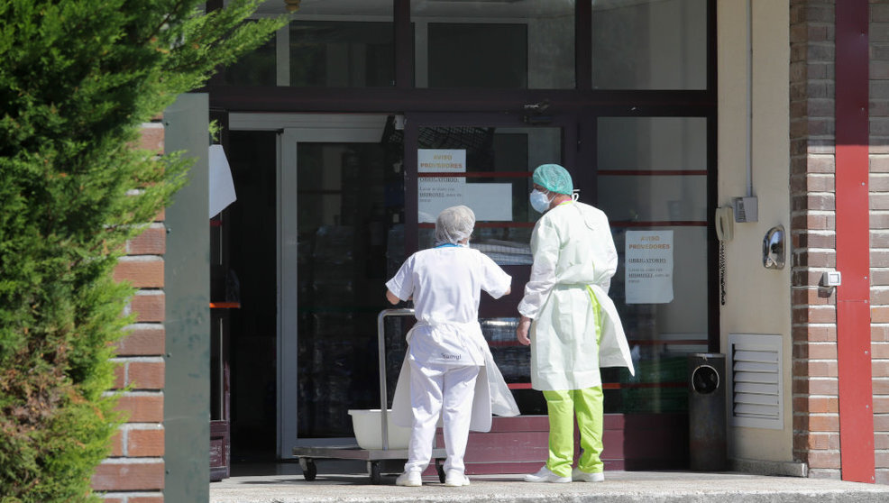 Dos trabajadores conversan en la puerta de una residencia