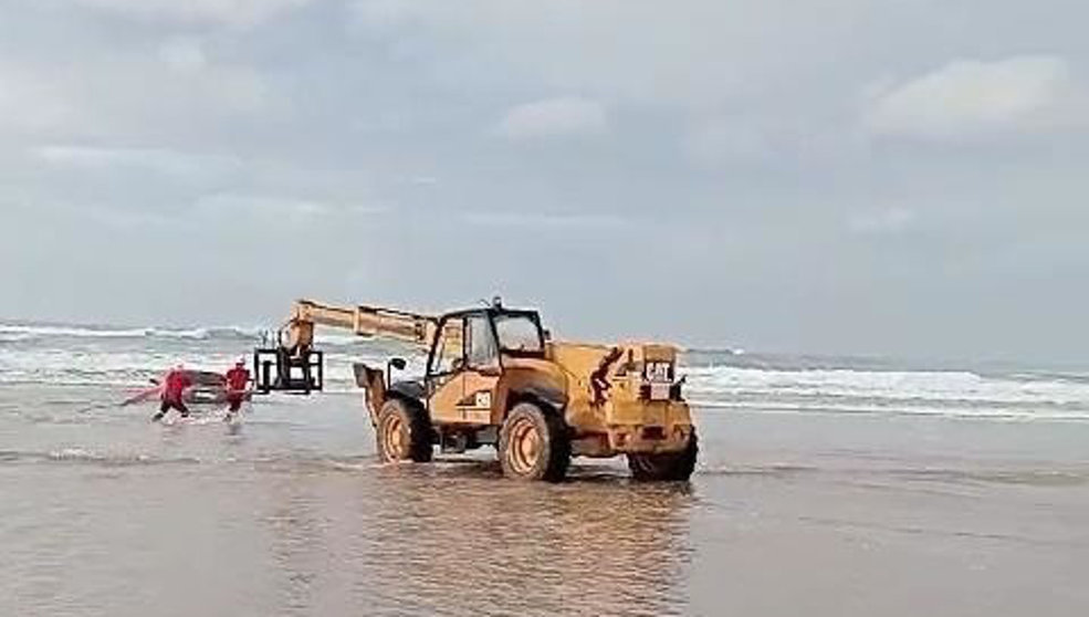 Un vehículo pesado saca del mar, en la playa de Oyambre, al turismo que quedó encallado