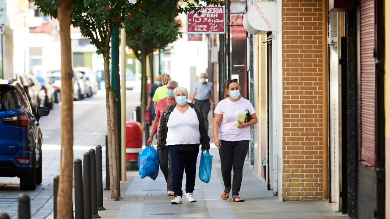 Transeúntes pasean por las calles del barrio La Inmobiliaria de Torrelavega