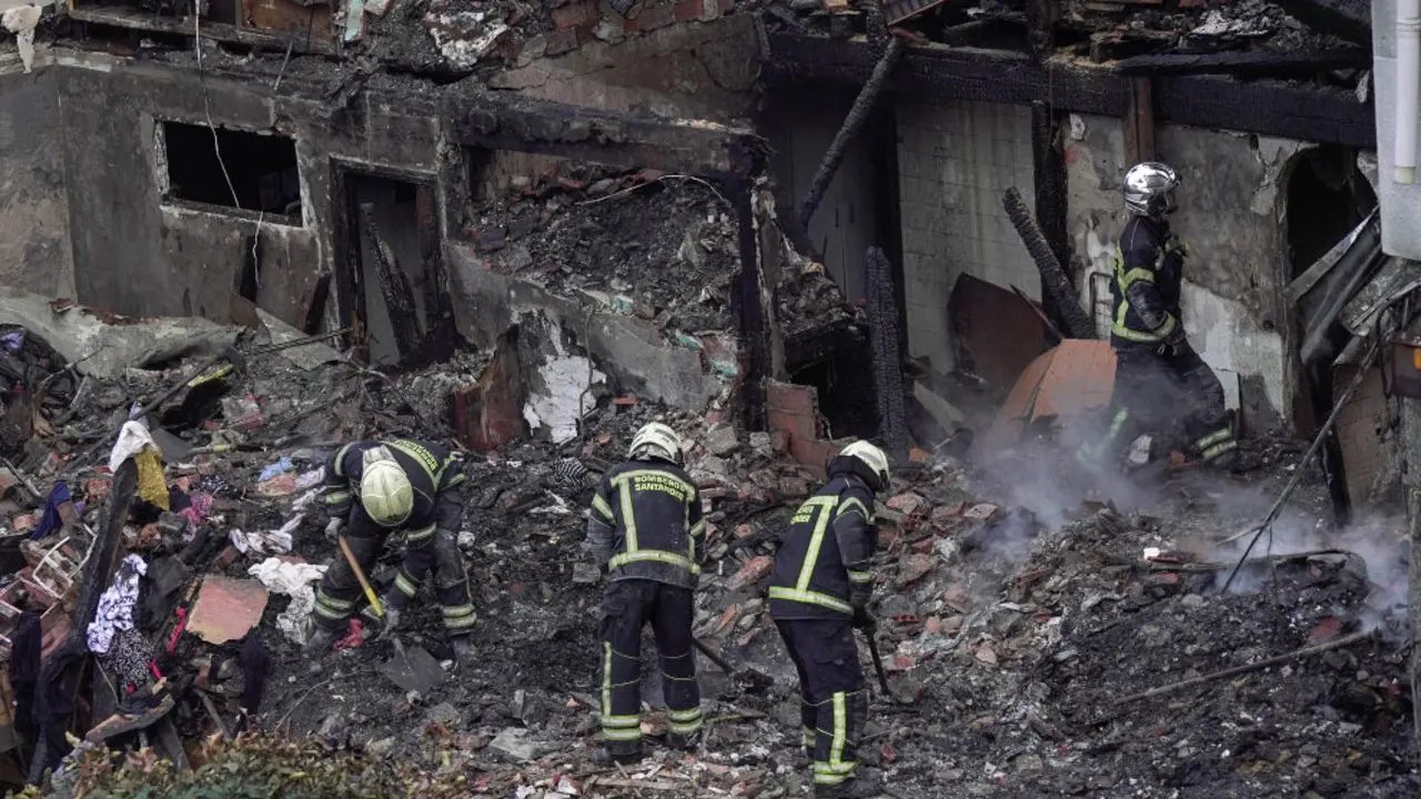 Agentes del equipo de bomberos trabaja en el edificio derrumbado,